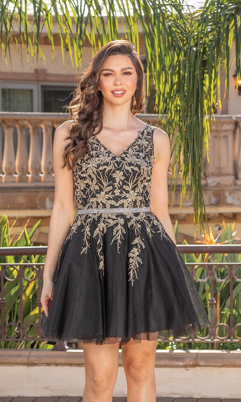A woman stands outdoors before greenery and a building, wearing a Short Prom Dress with Embroidered Sheer Bodice—sleeveless, black, with gold floral embroidery and an elegant embroidered bodice.